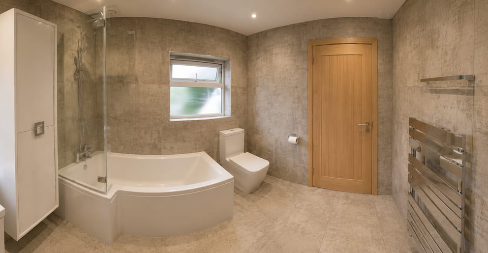 Warm Concrete & Oak Family Bathroom — Concrete-effect microcement, oak accents, shower-bath family bathroom by Bright Bathrooms, Greater Manchester
